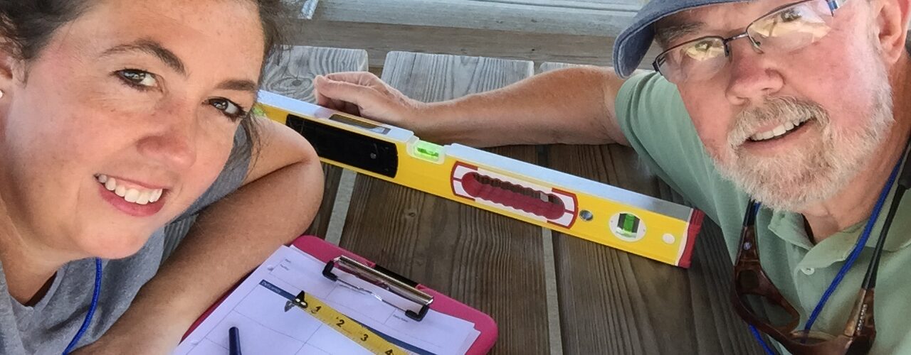 Jennifer Skulski and Rich Bowerman take a selfie with digital level, tape measure and clip board.